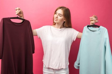 Güzel bir genç kız portresi seçer bir elbise tespit, pembe, izole reklam