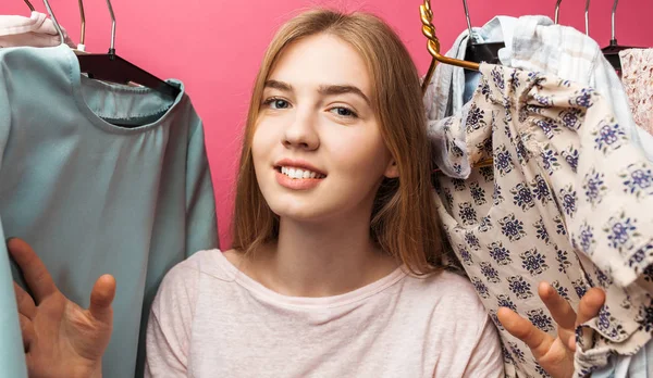 Портрет красивой молодой девушки выбирает платье, девушка внутри ее гардероб изолирован на розовом фоне, реклама — стоковое фото