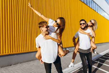 Bir grup arkadaş güler ve şehir merkezinde dolaşır.