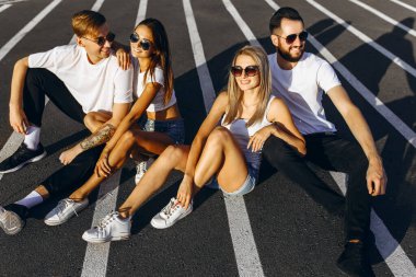 Bir grup genç arkadaş eğleniyor ve birlikte oturuyorlar.