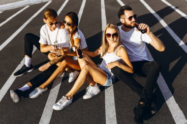 Bir grup genç arkadaş eğleniyor ve birlikte oturuyorlar.
