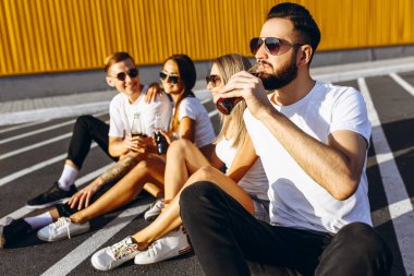 Bir grup genç arkadaş eğleniyor ve birlikte oturuyorlar.