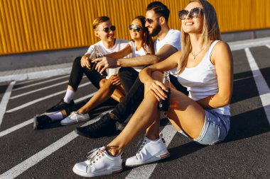 Bir grup genç arkadaş eğleniyor ve birlikte oturuyorlar.