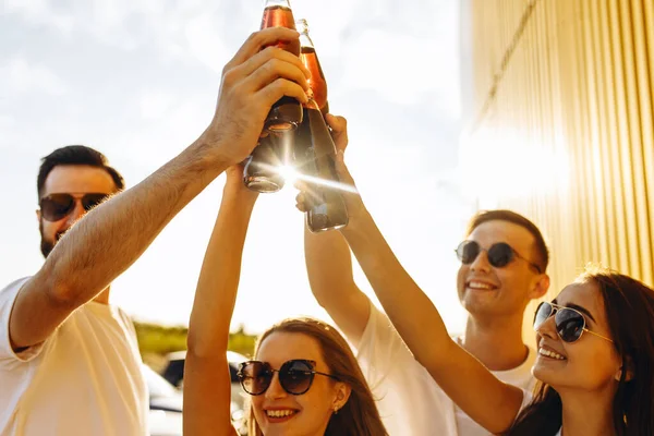 Towarzystwo pozytywnych przyjaciół, z drinkami w ręku świętuje — Zdjęcie stockowe