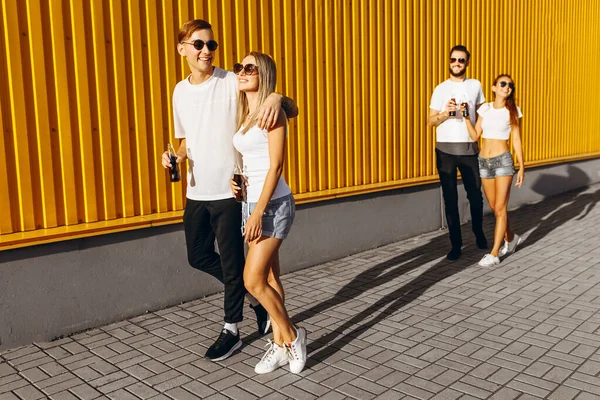 A group of young men and women, couples walking down the street — Stockfoto