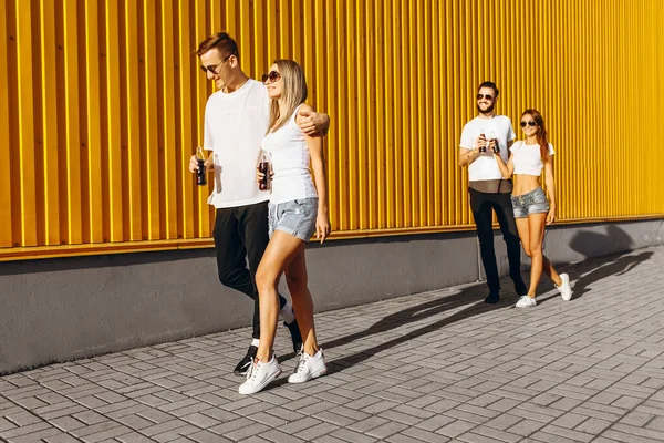 Un groupe de jeunes hommes et femmes, des couples marchant dans la rue — Photo