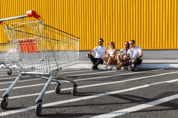 Un groupe de jeunes amis traînent dans la ville assis sur l'asp — Photo