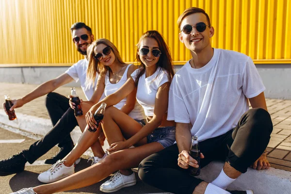 Un gruppo di giovani amici si ritrovano in città seduti sull'aspide — Foto Stock