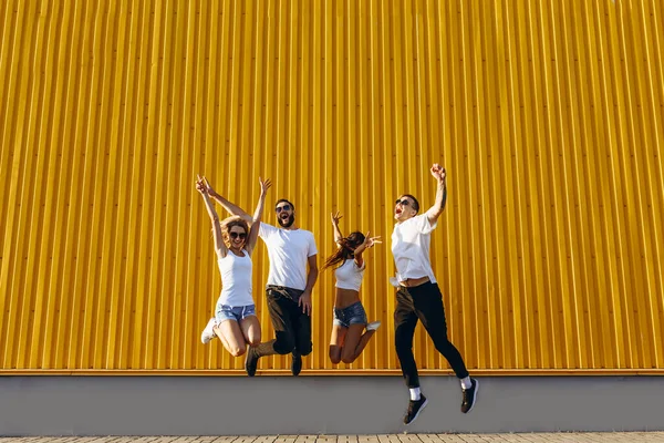 Szczęśliwi młodzi przyjaciele, mężczyźni i kobiety dobrze się bawią i skaczą po mieście — Zdjęcie stockowe