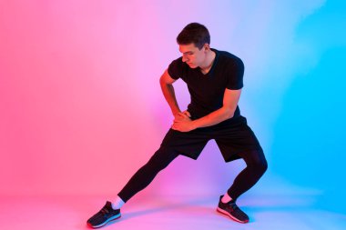 Çekici genç atletik adam kulaklıkla müzik dinliyor.