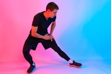 Çekici genç atletik adam kulaklıkla müzik dinliyor.