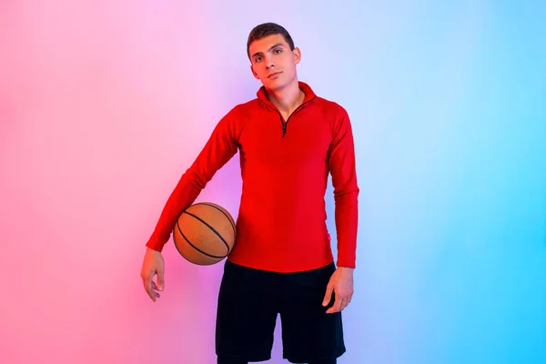 Hombre atlético joven, con baloncesto, posando en el fondo con n — Foto de Stock