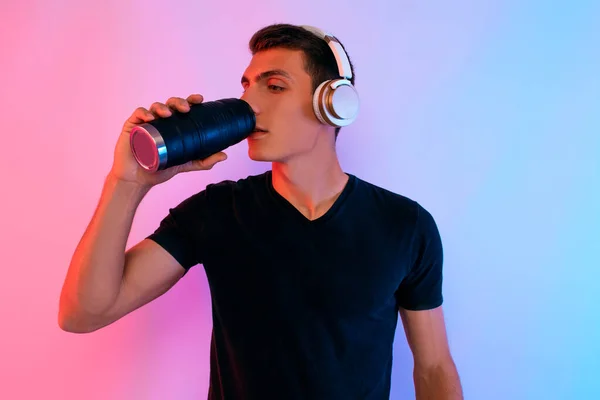 Atlético joven con auriculares y una botella de agua en el — Foto de Stock