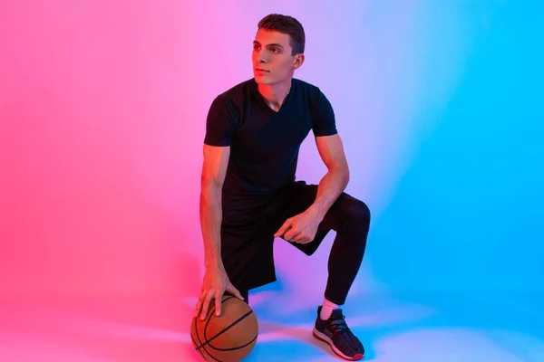 Hombre atlético joven, con baloncesto, posando en el fondo con n — Foto de Stock