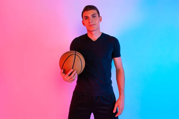 Hombre atlético joven, con baloncesto, posando en el fondo con n — Foto de Stock