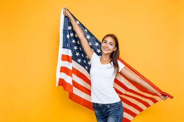 Joven hermosa chica en una camiseta blanca con la bandera americana , —  Fotos de Stock