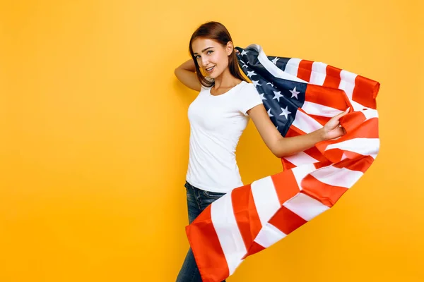 Young beautiful girl in a white t-shirt with the American flag, — Stock Photo, Image