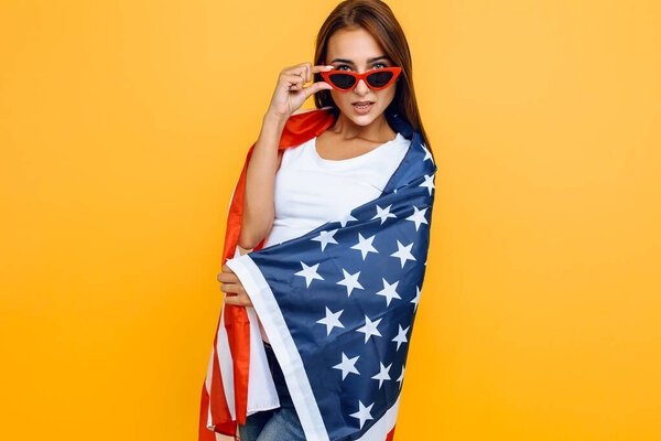 young beautiful girl in sunglasses, with American flag, having f