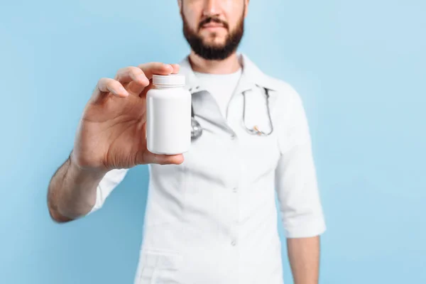Médico con una bata blanca con pastillas — Foto de Stock