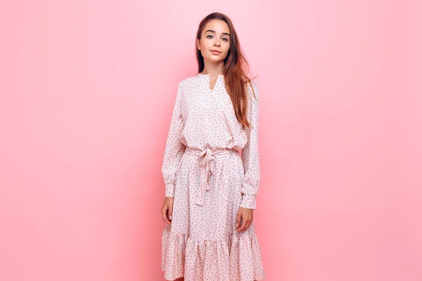 Junge Frau in einem eleganten Kleid. Mädchen posiert auf rosa Hintergrund — Stockfoto