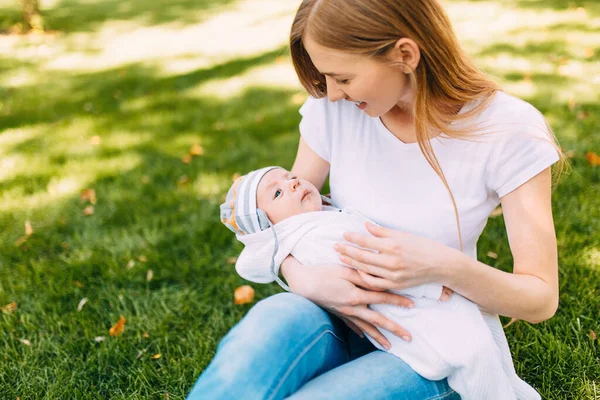 Keluarga bahagia di udara segar, ibu dengan bayi dalam pelukannya — Stok Foto