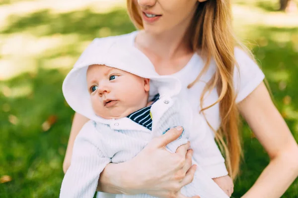 Keluarga bahagia di udara segar, ibu dengan bayi dalam pelukannya — Stok Foto