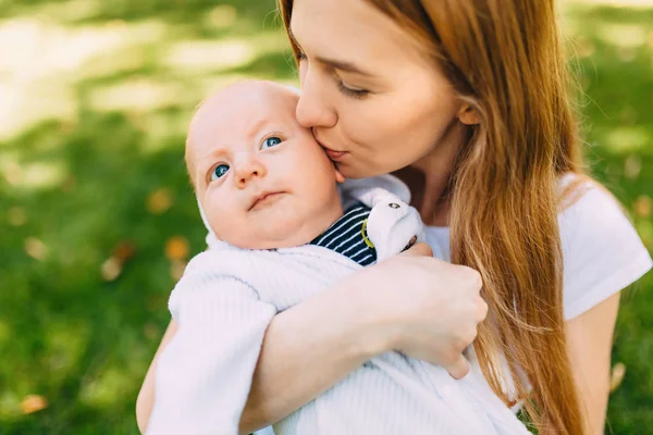 Keluarga bahagia di udara segar, ibu dengan bayi dalam pelukannya — Stok Foto
