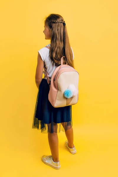 Retrato de una colegiala sonriente con una mochila en un yel —  Fotos de Stock