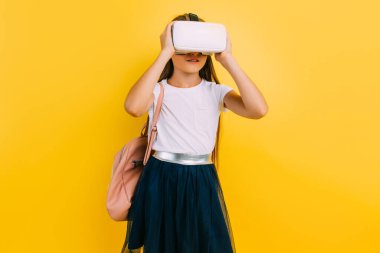 Little girl in school uniform with virtual reality glasses