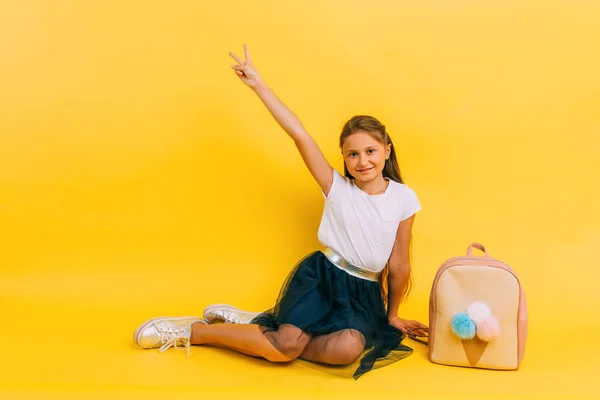 Chica de la escuela en ropa de la escuela sobre un fondo amarillo —  Fotos de Stock