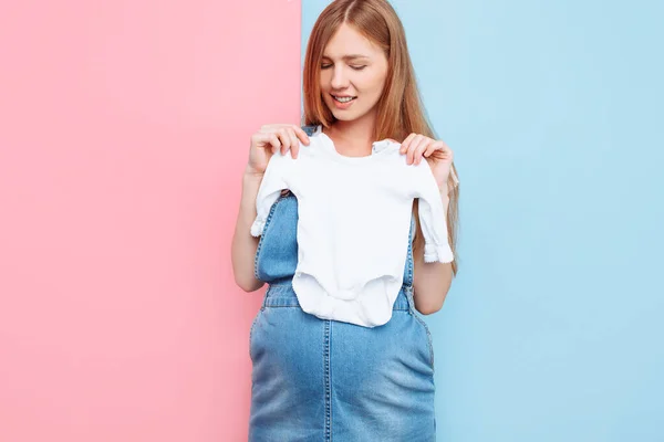 Feliz Bela Jovem Grávida Segurando Roupas Bebê Suas Mãos Sobre — Fotografia de Stock