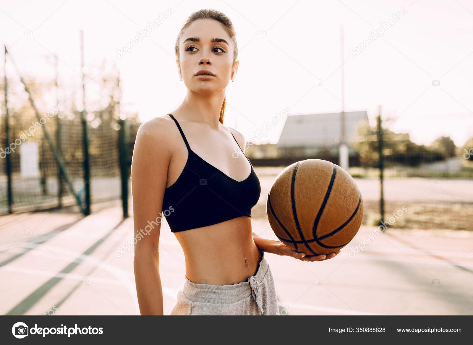 Jovem praticando esportes, jogando basquete ao nascer do sol