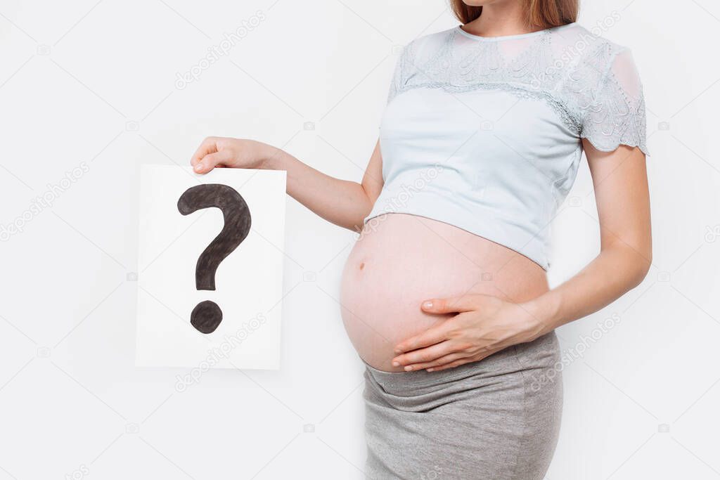 Image of a pregnant woman holding a paper with a question mark near the pregnant belly, on a white background