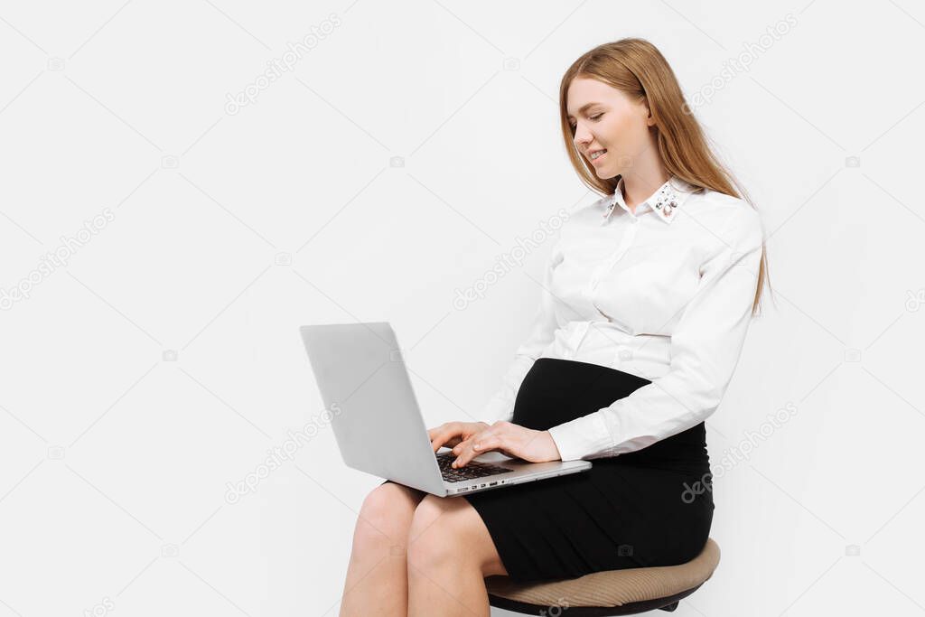 Image of young pregnant businesswoman in glasses, girl working with laptop, sitting on chair, on white background