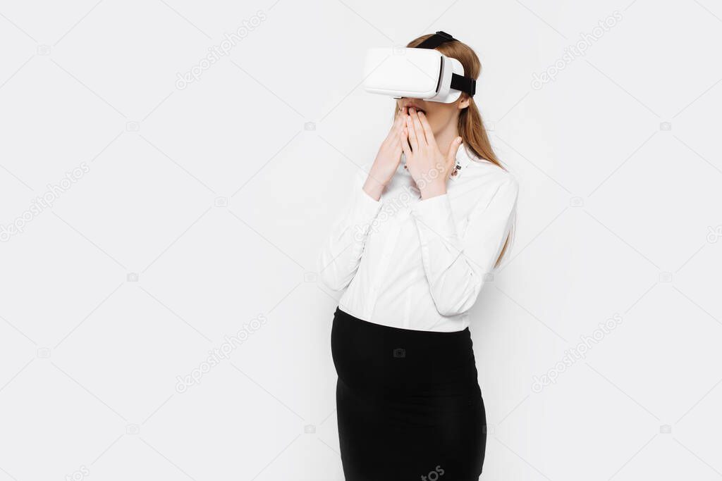 Image of a young pregnant businesswoman wearing virtual reality glasses, entertainment in the workplace, on a white background