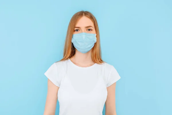 Protection from infectious diseases, coronavirus. A young girl wears a hygiene mask to prevent infection, airborne respiratory disease. closed Studio shot isolated on a blue background