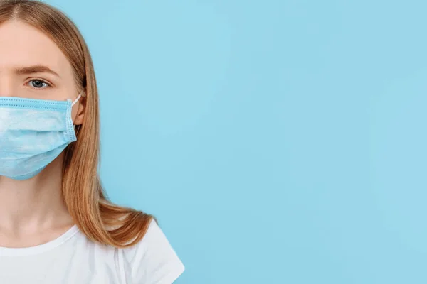 Protection from infectious diseases, coronavirus. A young girl wears a hygiene mask to prevent infection, airborne respiratory disease. closed Studio shot isolated on a blue background