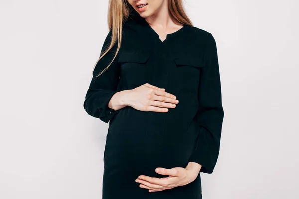 白い背景にポーズをとる黒のドレスの美しい妊婦 ファッション写真妊娠 — ストック写真