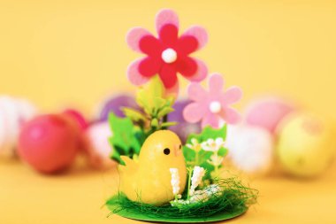 Paskalya pilici ve boyalı Paskalya yumurtaları sarı arka planda izole. Paskalya dekorasyonu, Paskalya