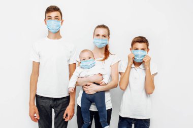 Aile bireyleri ve çocuklar enfeksiyonu önlemek için tıbbi maske takarlar. Solunum hastalıkları, beyaz arka planda izole edilmiş koronavirüs.
