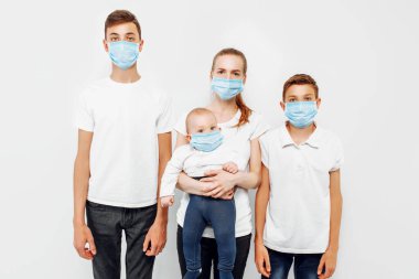 Aile bireyleri ve çocuklar enfeksiyonu önlemek için tıbbi maske takarlar. Solunum hastalıkları, beyaz arka planda izole edilmiş koronavirüs.