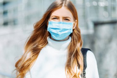 Koronovirüsten maske takmış güzel bir genç kız, eğitimsel kıskançlık geçmişi olan bir öğrenci, işten dönen kadınlar, uzaktan çalışma, covid-19