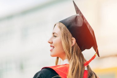 Mezuniyet günü, arka plan, mezuniyet şapkası ve elbisesi olan genç bir öğrenci. Başarı kavramı