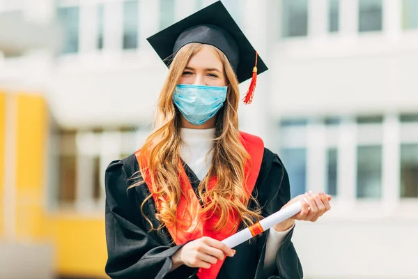 Eine Doktorandin Medizinischer Schutzmaske Einem Schwarzen Abschlusskleid Mit Einem Diplom — Stockfoto