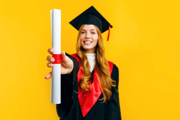 快乐迷人的毕业生穿着主人的衣服 背景是黄色的文凭 毕业典礼的概念 — 图库照片