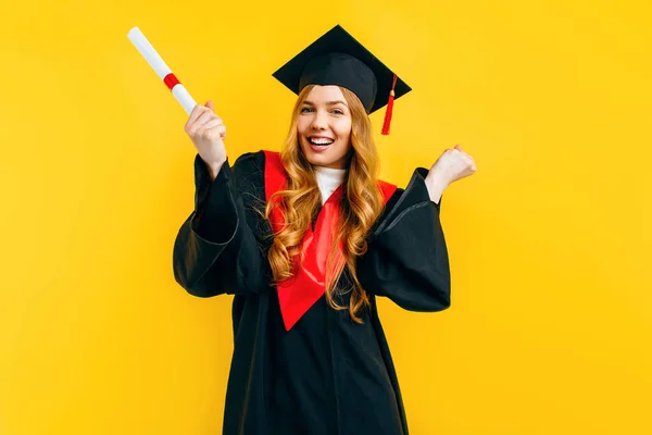 Szczęśliwa Absolwentka Dyplomem Pokazuje Gest Zwycięstwa Sukcesu Żółtym Tle — Zdjęcie stockowe