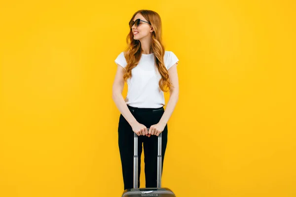 黄色の背景にスーツケース付きの幸せな美しい女性 ビジネスの概念 — ストック写真