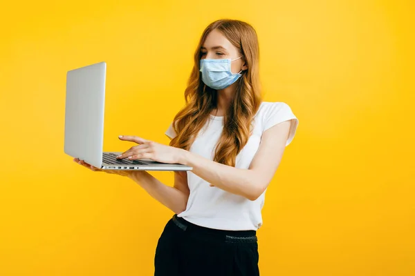 Egy Fiatal Védő Orvosi Maszkban Egy Laptoppal Sárga Háttérrel Karantén — Stock Fotó