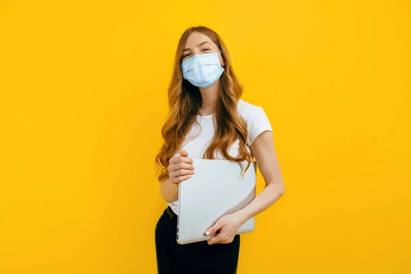 Μια Νεαρή Γυναίκα Προστατευτική Ιατρική Μάσκα Ένα Λάπτοπ Κίτρινο Φόντο — Φωτογραφία Αρχείου