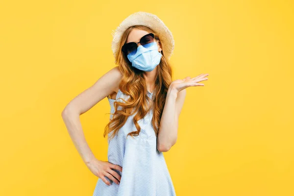 Portrait of a girl in a hat in summer, wears a medical protective mask against a viral infection, on a yellow isolated background. Quarantine, coronavirus, summer